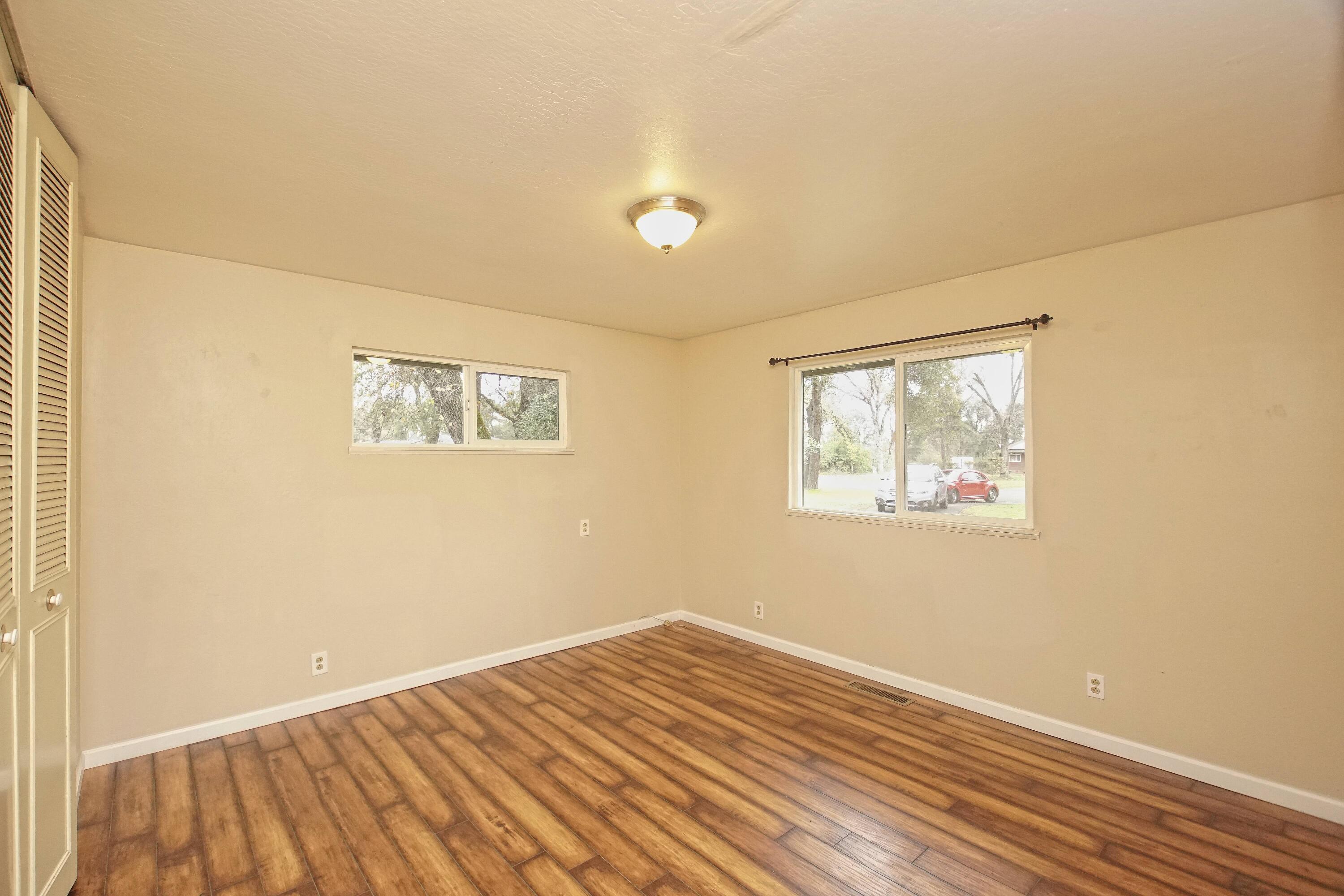 8440 Redbank Road Redding, CA 96001 - Photo 36 of 49 a view of an empty room with wooden floor and a window