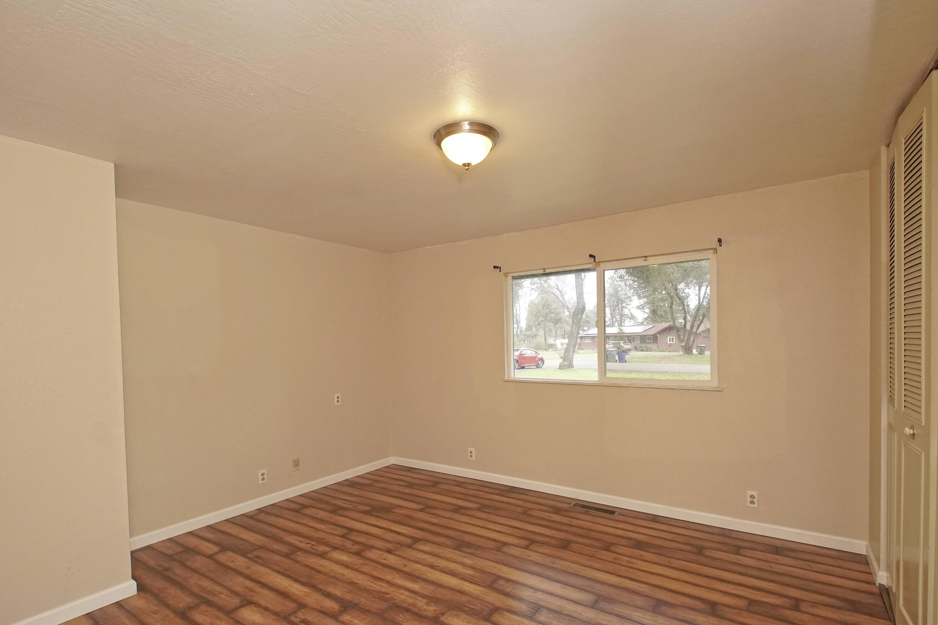 8440 Redbank Road Redding, CA 96001 - Photo 38 of 49 a view of an empty room with wooden floor and a window
