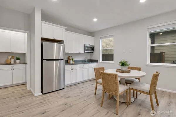 a view of kitchen with refrigerator and wooden floor