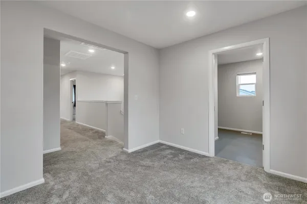an empty room with mirror and a bathroom