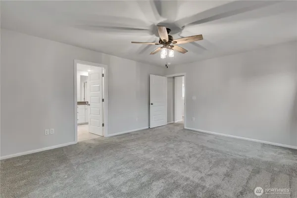 an empty room with closet and a ceiling fan