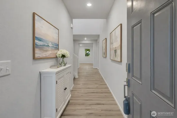 a hallway with white doors wooden floor and stairs