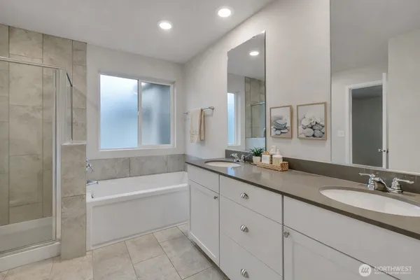a bathroom with a granite countertop sink mirror and bathtub
