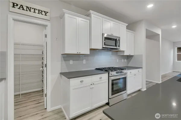 a kitchen with stainless steel appliances granite countertop a stove a microwave and a sink