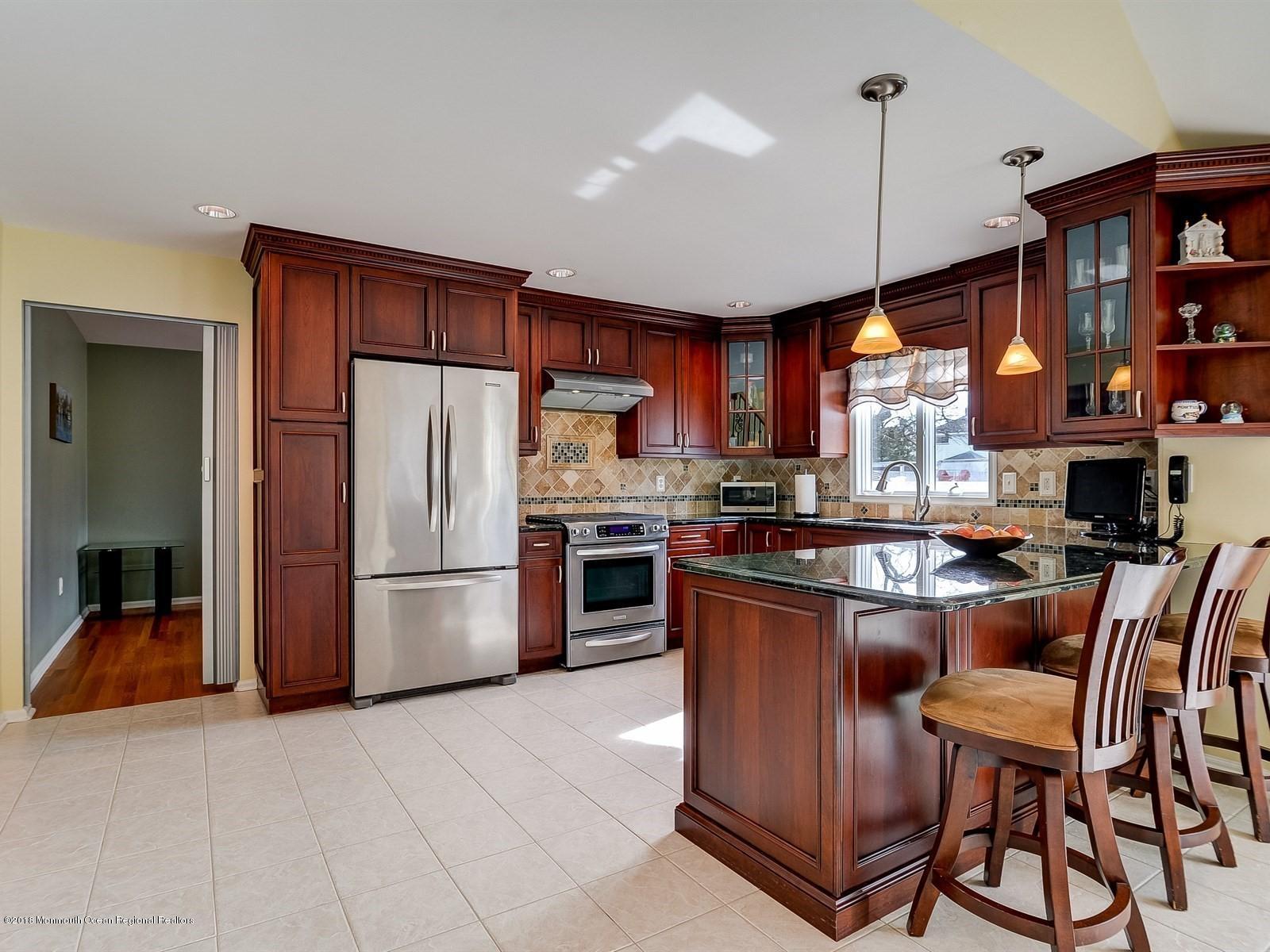 13 Hamilton Road Englishtown, NJ 07726 - Photo 6 of 24 a kitchen with stainless steel appliances granite countertop a refrigerator a stove a sink and a dining table with chairs