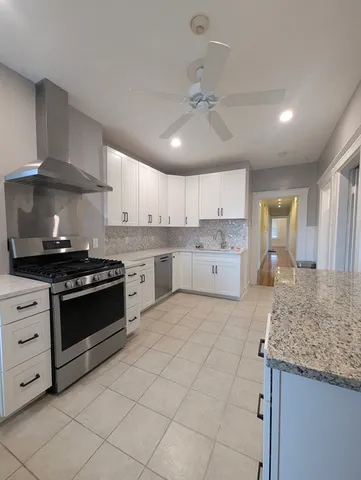 a kitchen with stainless steel appliances granite countertop a stove sink and cabinets