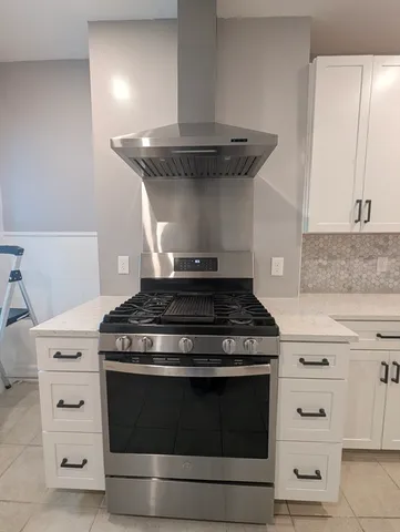 a stove top oven sitting inside of a kitchen