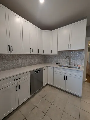 a kitchen with granite countertop white cabinets and white stainless steel appliances