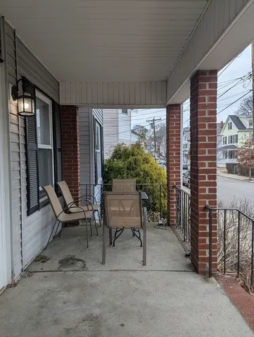 a balcony with furniture and a potted plant