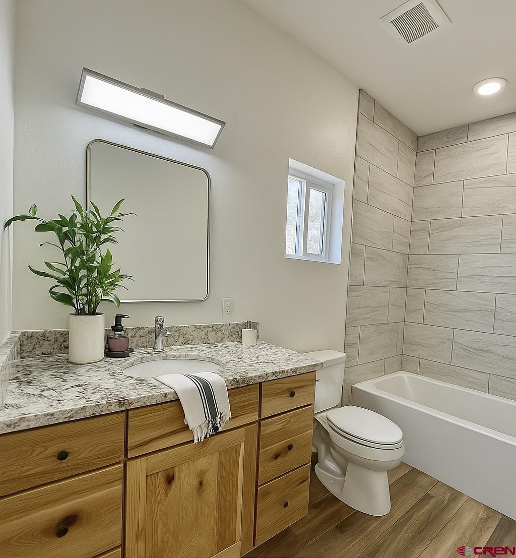 18755 H Road Delta, CO 81416 - Photo 17 of 26 a bathroom with a granite countertop toilet sink and mirror