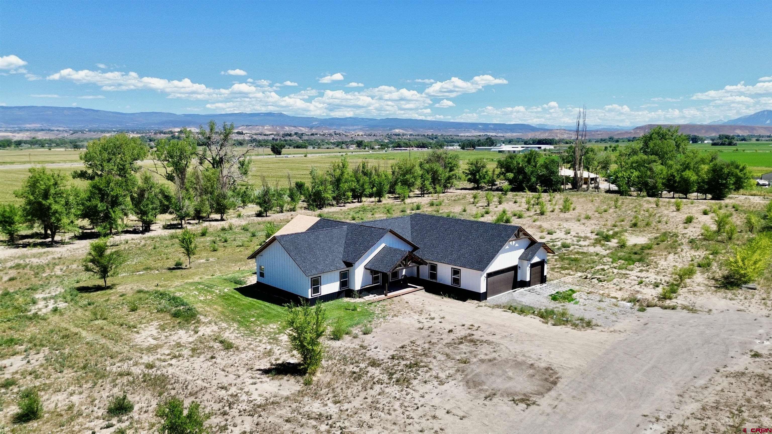18755 H Road Delta, CO 81416 - Photo 24 of 26 a view of a house with a yard and green space