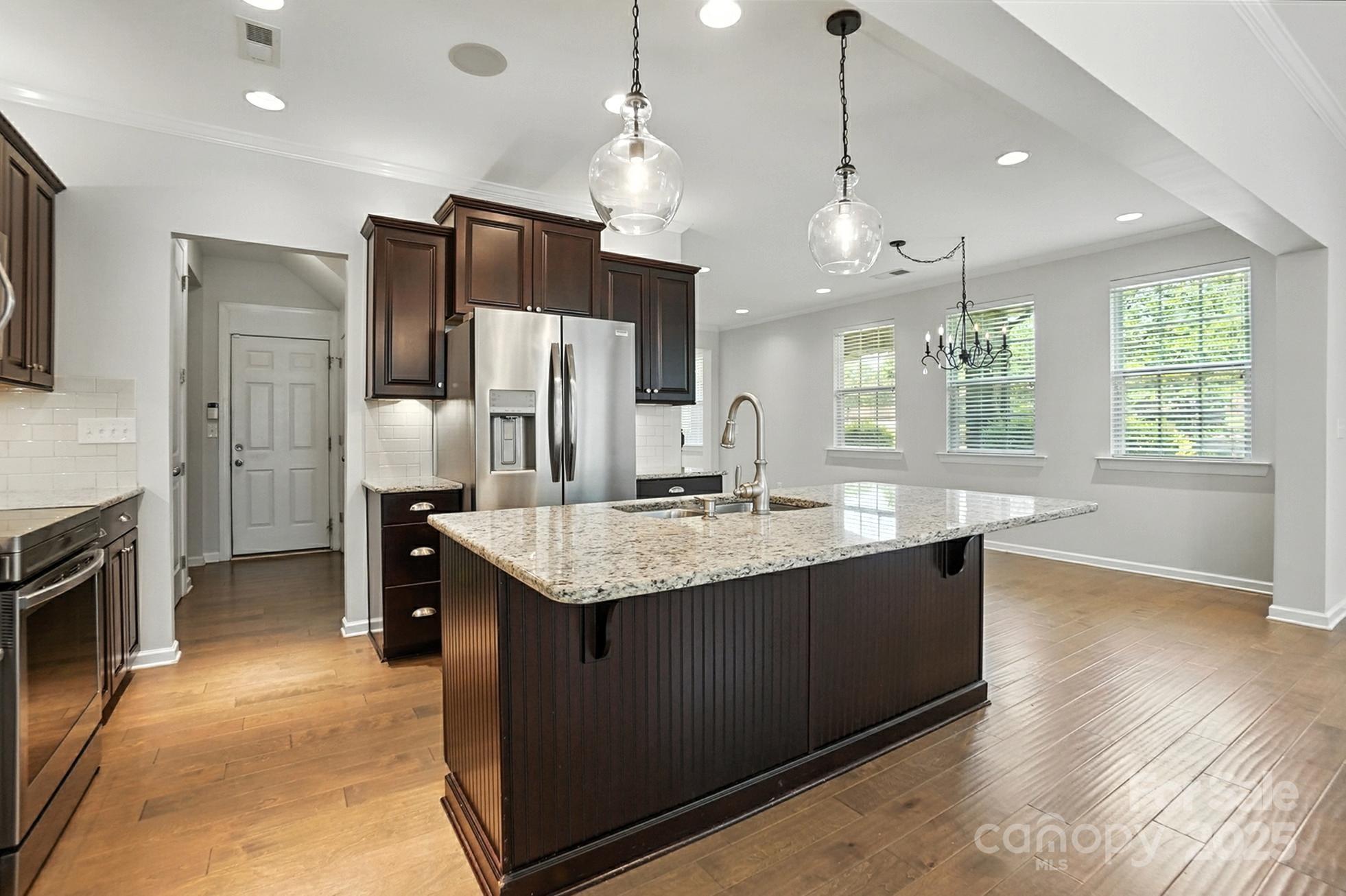 809 Ayrshire Avenue Fort Mill, SC 29708 - Photo 15 of 48 a large kitchen with granite countertop a large kitchen island and a refrigerator
