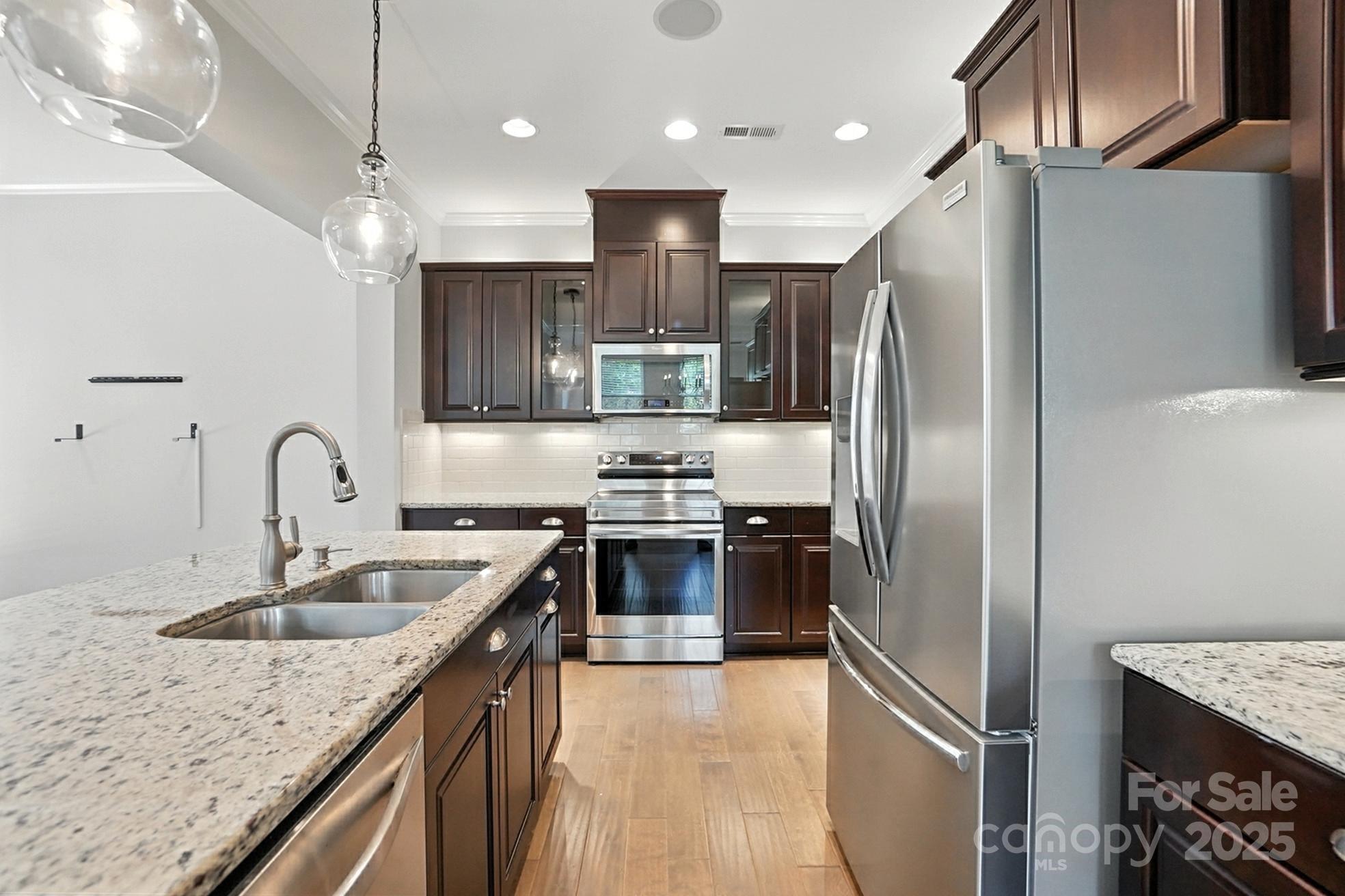 809 Ayrshire Avenue Fort Mill, SC 29708 - Photo 17 of 48 a kitchen with stainless steel appliances granite countertop a sink refrigerator and microwave