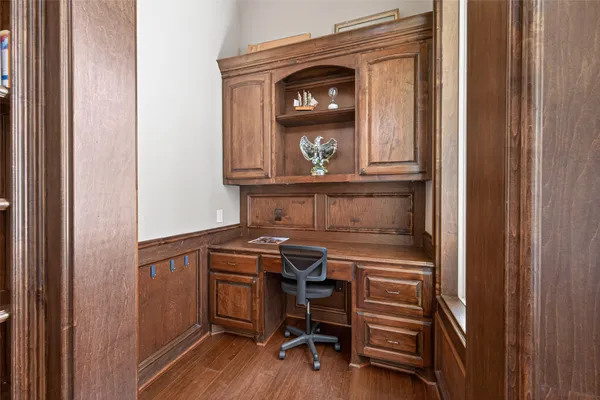 a view of a hallway with a chair and wooden floor