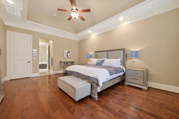 a bedroom with a bed and wooden floor