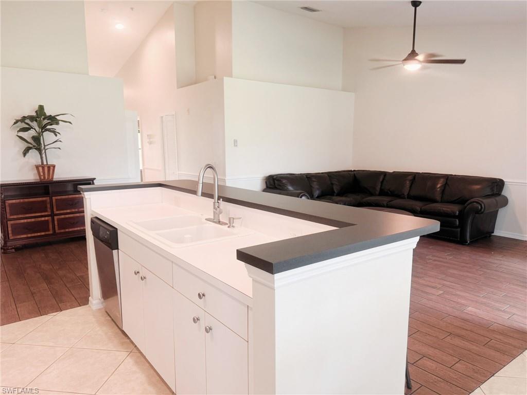 21301 Lancaster Run, Unit 822 Estero, FL 33928 - Photo 20 of 20 a kitchen with a sink and a stove with wooden floor