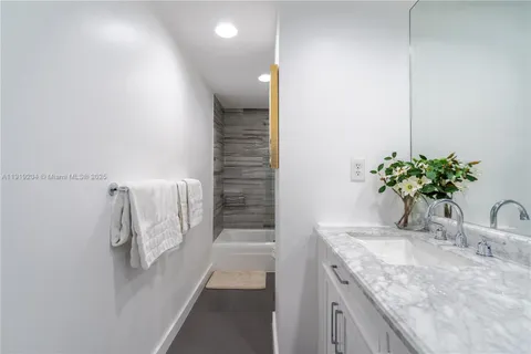 a bathroom with a granite countertop sink a vanity and shower