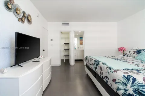 a bedroom with a bed and flat screen tv