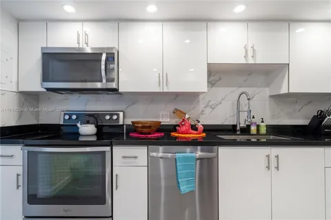 a kitchen with stainless steel appliances granite countertop a sink stove and cabinets