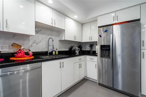 a kitchen with stainless steel appliances granite countertop a refrigerator and a sink