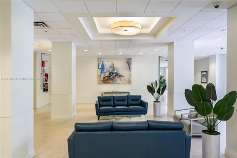 a living room with furniture potted plant and a large window