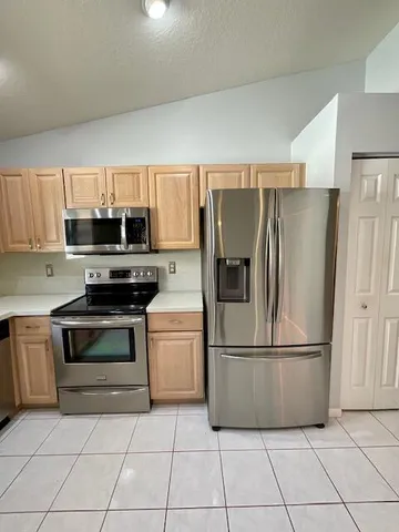 a large kitchen with kitchen island white cabinets and appliances