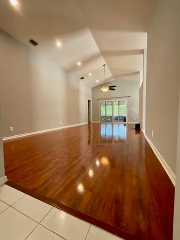 a view of an empty room with wooden floor