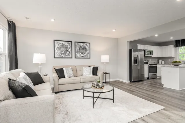 a living room with furniture and kitchen view