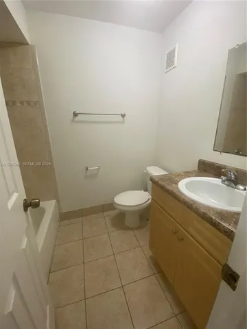 a bathroom with a granite countertop sink a toilet and a mirror