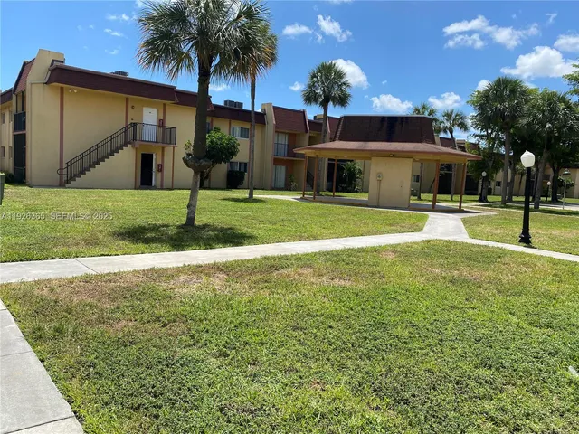 a view of a house with backyard and trees