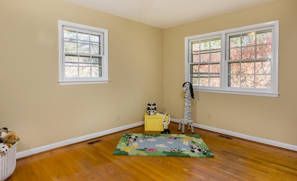 303 West Cornwall Road Cary, NC 27511 - Photo 13 of 22 a bedroom with a bed and wooden floor