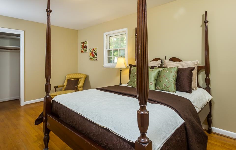 303 West Cornwall Road Cary, NC 27511 - Photo 9 of 22 a bedroom with a bed and wooden floor