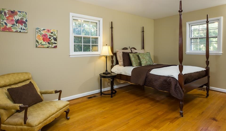 303 West Cornwall Road Cary, NC 27511 - Photo 10 of 22 a bedroom with a bed and wooden floor