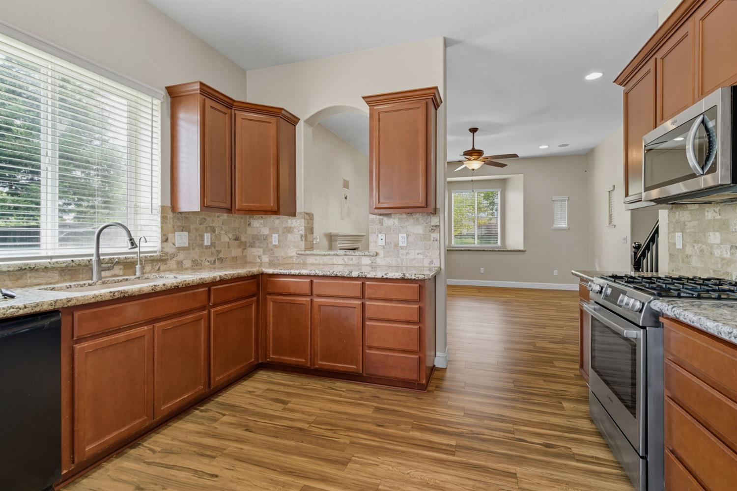 433 Travertine Drive Ripon, CA 95366 - Photo 12 of 38 a kitchen with stainless steel appliances granite countertop a sink stove and refrigerator