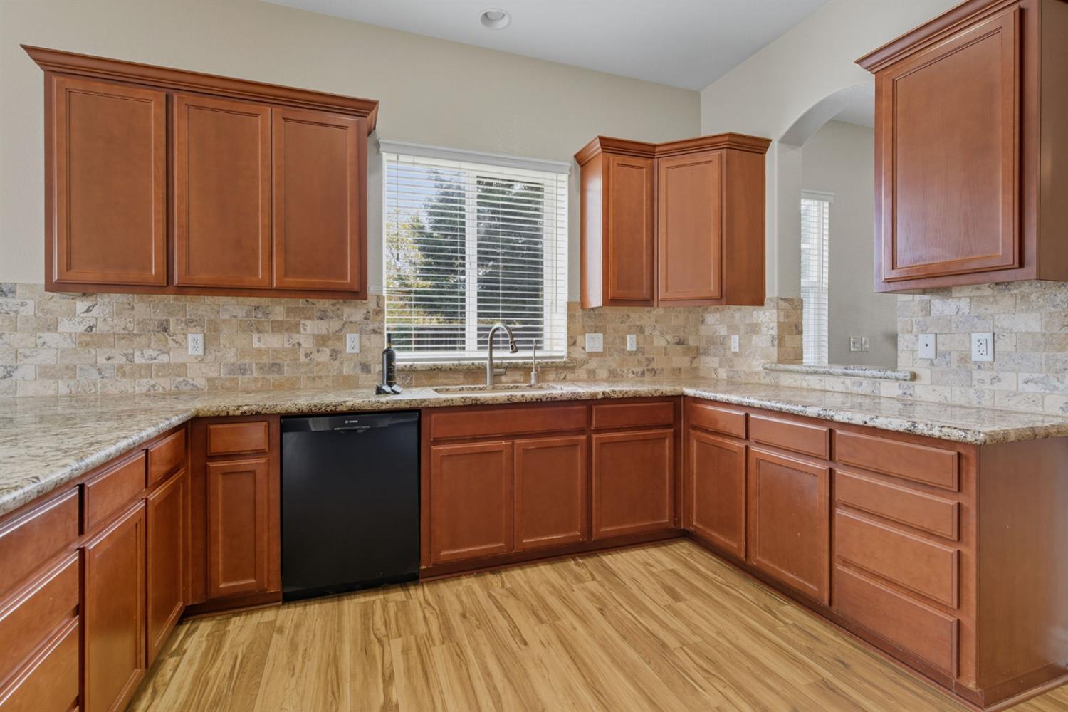 433 Travertine Drive Ripon, CA 95366 - Photo 13 of 38 a kitchen with stainless steel appliances granite countertop wooden cabinets a sink and dishwasher