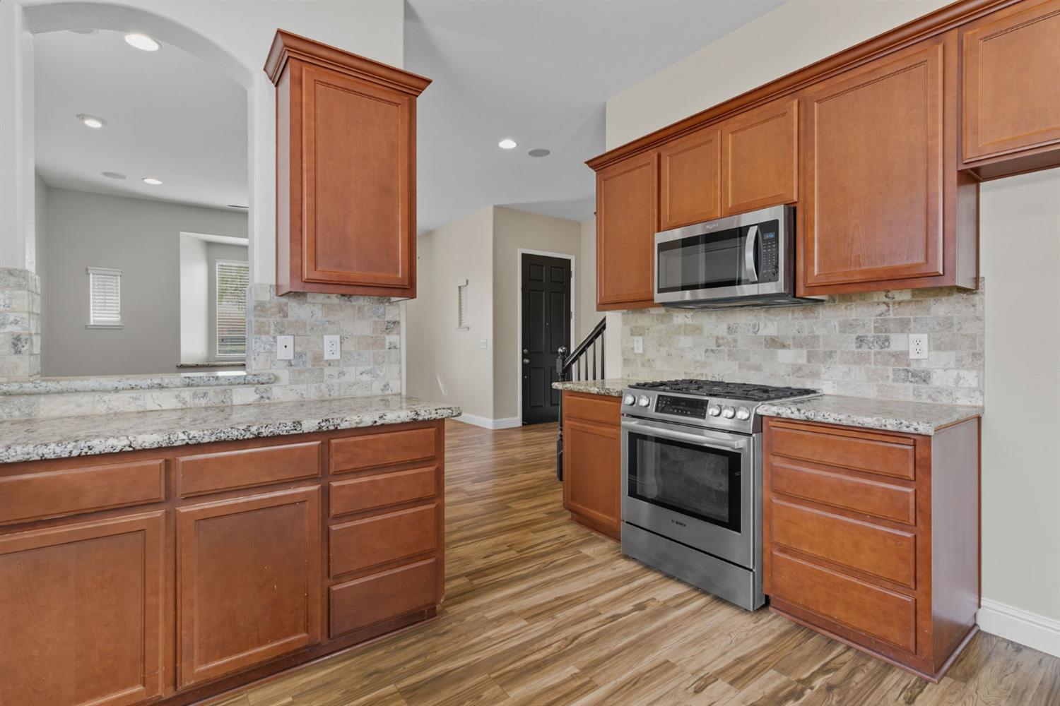 433 Travertine Drive Ripon, CA 95366 - Photo 15 of 38 a kitchen with stainless steel appliances granite countertop a stove microwave and cabinets