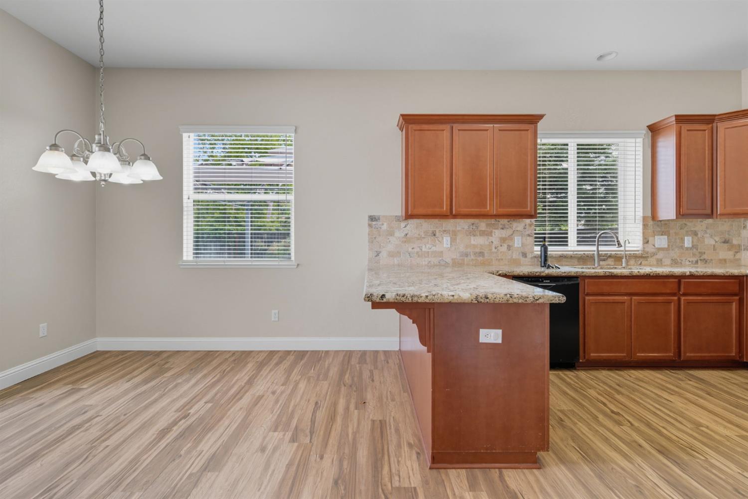433 Travertine Drive Ripon, CA 95366 - Photo 16 of 38 a kitchen with granite countertop a sink cabinets and wooden floor