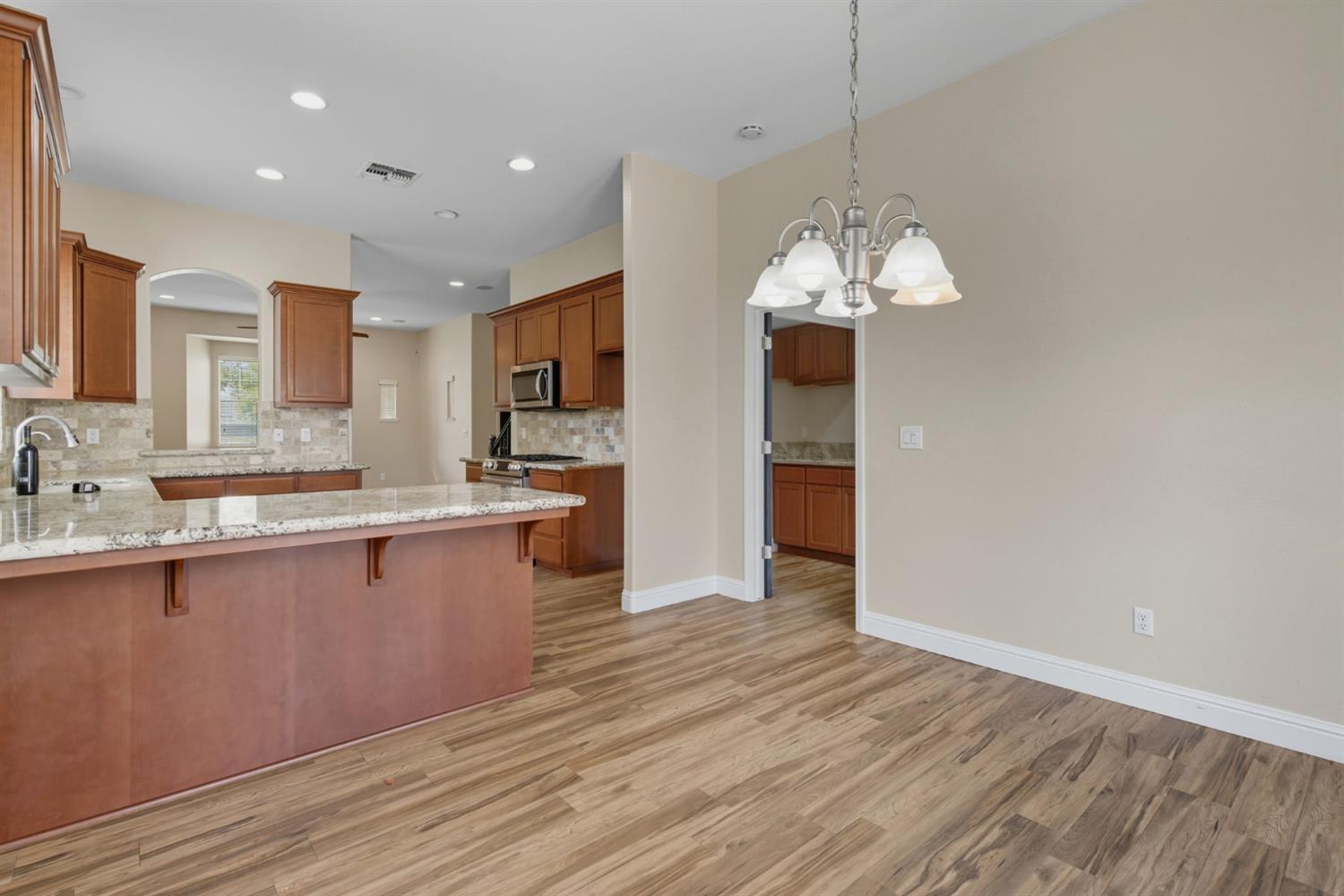 433 Travertine Drive Ripon, CA 95366 - Photo 18 of 38 a kitchen with stainless steel appliances granite countertop a sink cabinets and wooden floor