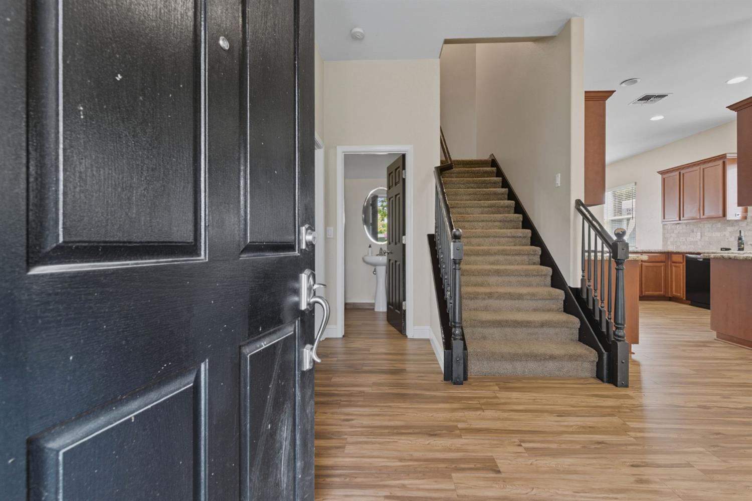 433 Travertine Drive Ripon, CA 95366 - Photo 6 of 38 a view of a hallway with wooden floor and staircase