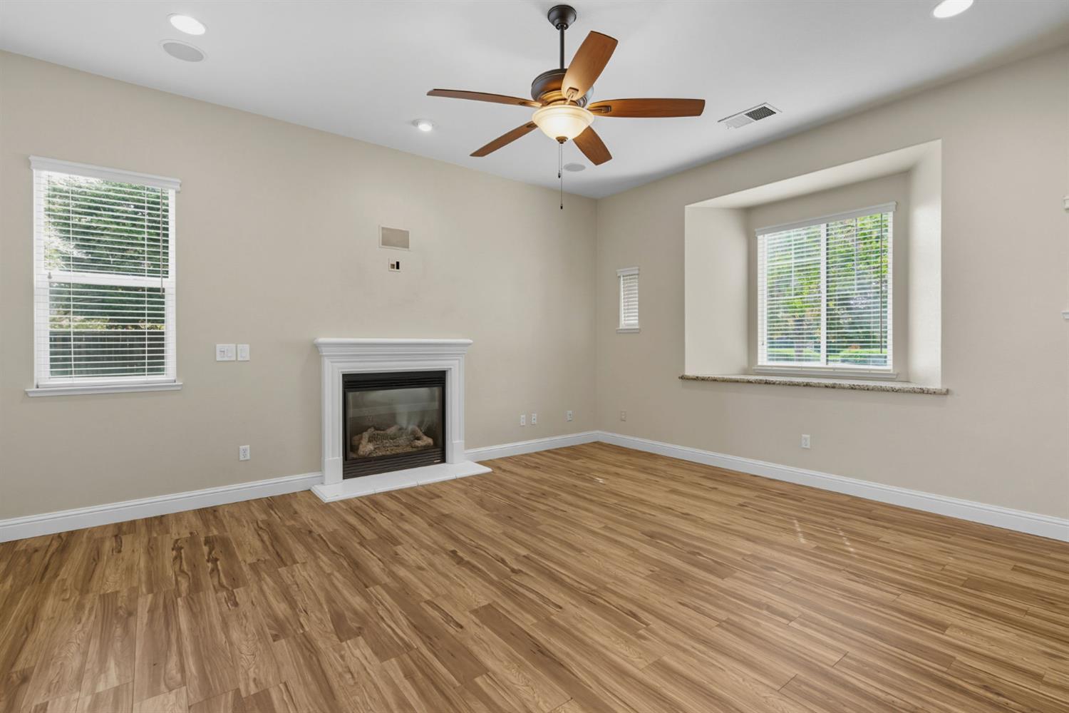 433 Travertine Drive Ripon, CA 95366 - Photo 7 of 38 a view of an empty room with a window and wooden floor