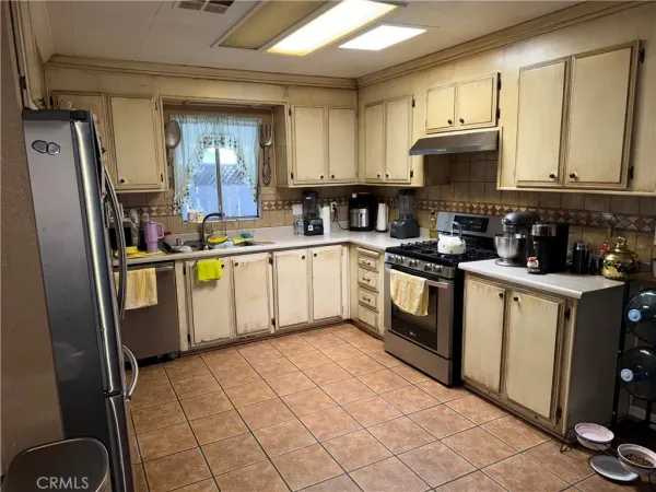 a kitchen with a sink a stove top oven and cabinetry