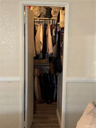 a view of walk in closet with clothes and shoes