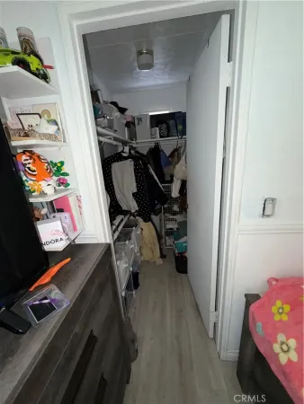 a view of walk in closet with clothes and shoes