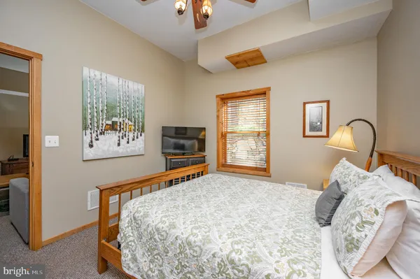 a bedroom with a large bed and large windows