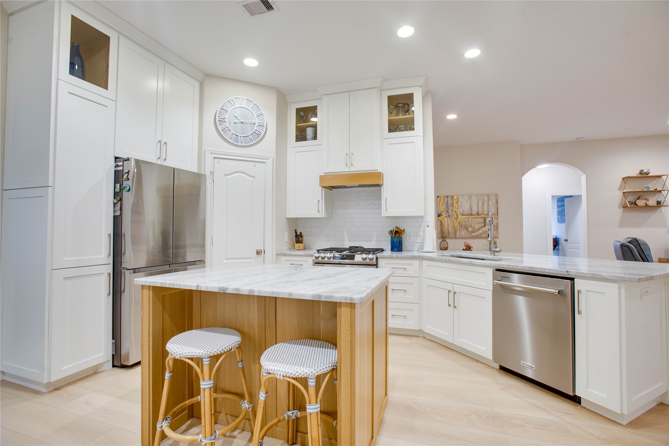 30 Fraiser Fir Place Spring, TX 77389 - Photo 10 of 35 a kitchen with stainless steel appliances granite countertop a stove a refrigerator a sink dishwasher and white cabinets with wooden floor