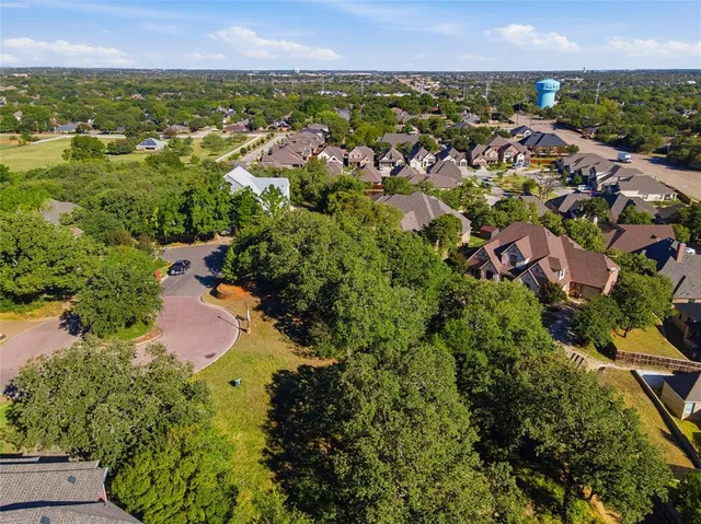 an aerial view of residential houses with outdoor space and trees