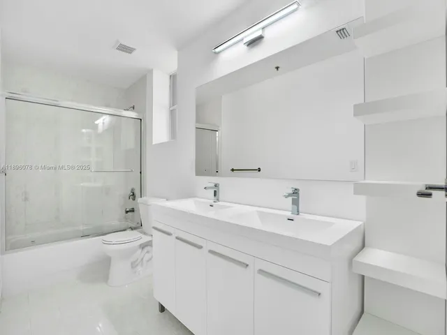 a bathroom with a sink toilet mirror and shower