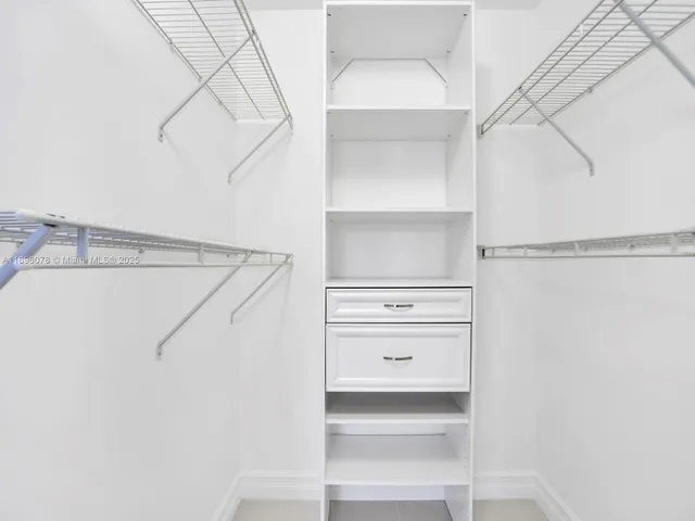 a view of walk in closet with empty racks