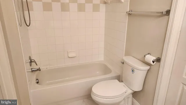 a white toilet sitting next to a bath tub