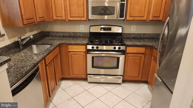 a kitchen with stainless steel appliances granite countertop a stove a microwave and a sink